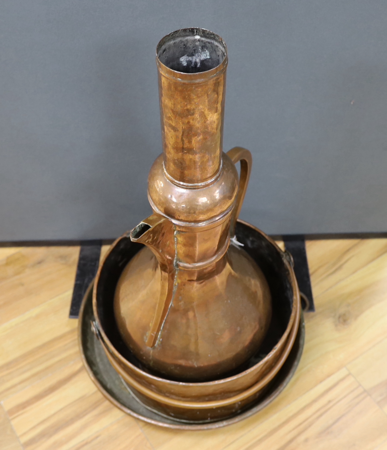 A shallow copper dish a copper cooking pot and a large, Middle Eastern coffee pot,-77cm high